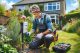 Un electricista en el jardín de un hogar protegiendo un enchufe que está en el exterior.